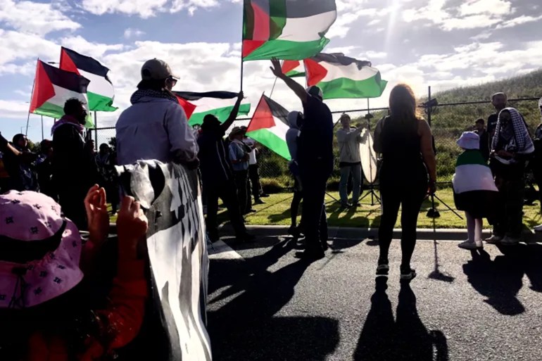 Protester wave Palestinian flags as they blockade the Port of Melbourne [Briana Charles/Al Jazeera]