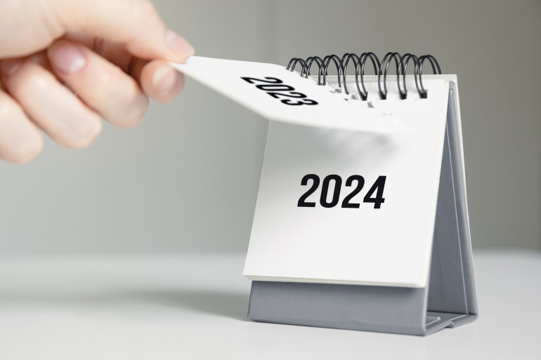 a woman's hand turns over a calendar sheet. year change froa woman's hand turns over a calendar sheet. year change from 2023 to 2024m 2023 to 2024