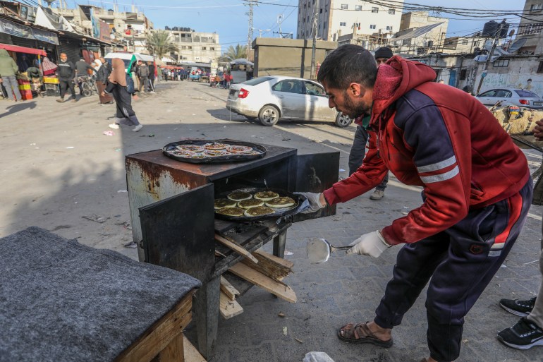 داخل خيمة نزوح بمدينة رفح جنوبي قطاع غزة، تنشغل عائلة الفلسطيني جهاد عاشور بإعداد قطع دائرية الشكل من فطائر "البيتزا" و"مناقيش الزعتر"، ضمن مشروع صغير بدأته مؤخرا للحصول على لقمة العيش في ظل تدهور الأوضاع الاقتصادية للسكان بفعل الحرب المستمرة منذ 7 أكتوبر/ تشرين الأول الماضي.ولإنجاز العمل بوتيرة سريعة، يوزع أفراد الأسرة داخل هذه الخيمة التي نصبوها بأحد شوارع المدينة، مراحل صناعة الفطائر على بعضهم، فتعمل واحدة من السيدات على تجهيز العجينة والأخرى تعكف على فردها لتصبح بسطح مستوٍ.وأما الفلسطيني "عاشور" يساهم في ترتيب مكونات البيتزا البسيطة على هذه الفطائر، والتي تشمل "صلصة الطماطم، وقطع صغيرة وقليلة جدا لا تتجاوز الاثنتين من لحوم (المرتديلا)، وشرائح قليلة من الفلفل الحلو وبعض المايونيز".هذه المكونات البسيطة بالكاد ينجح عاشور بالعثور عليها في الأسواق، ليشتريها بسعر مضاعف، حيث تفتقد هذه البيتزا أهم عناصرها وهي "الجبنة"، لكن الإقبال على شرائها ملحوظ لعدم قدرة النازحين على شراء مكوناتها أو خبزها.ويخبز عاشور هذه الفطائر داخل فرن يعمل على الحطب والفحم بدلا من غاز الطهي بسبب قلة توفره، وذلك في شارع عام، لجذب الزبائن لشراء هذه الفطائر التي تخرج ساخنة. ( Abed Rahim Khatib - وكالة الأناضول )