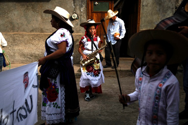 A girl with a saxophone takes part in the Purepecha New Year celebration in Ocumicho, Michoacan State, Mexico, on February 1, 2024. - Every year, Purepecha’s Indigenous people from different regions of Michoacan State celebrate the Fuego Nuevo Purepecha (Purepecha’s New Fire), a fire lighting ceremony to mark the start of the new year. (Photo by Rodrigo Oropeza / AFP)