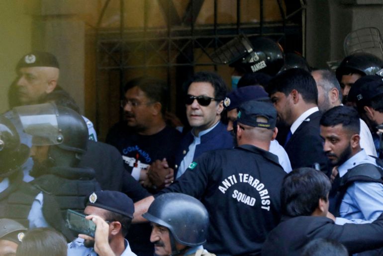 FILE PHOTO: Security officers escort Pakistan's former Prime Minister Imran Khan as he appeared in Islamabad High Court