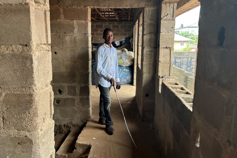 Visually-impaired Kehinde Olubotusun, who struggled to find information because he has no smartphone, and who is using an Artificial-Intelligence-powered mobile phone that works offline, walks at his house in Alimosho local government district in Lagos, Nigeria February 23, 2024. REUTERS/Seun Sanni