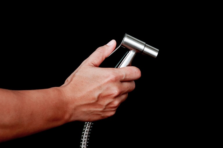 bidet shower in hand isolated on black background