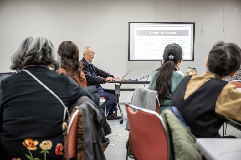 This picture taken on February 25, 2024 shows app developer Tomiji Suzuki (C) atteding a workshop in Tokyo. - Japanese 89-year-old Tomiji Suzuki started coding in retirement and is now making apps for the fast-growing elderly demographic, using ChatGPT to fine-tune his skills. (Photo by Philip FONG / AFP) / TO GO WITH 'JAPAN-TECH-LIFESTYLE-DEMOGRAPHICS-AI, FOCUS' BY KYOKO HASEGAWA / The erroneous mention[s] appearing in the metadata of this photo by Philip FONG has been modified in AFP systems in the following manner: [Tomiji] instead of [Tomoji]. Please immediately remove the erroneous mention[s] from all your online services and delete it (them) from your servers. If you have been authorized by AFP to distribute it (them) to third parties, please ensure that the same actions are carried out by them. Failure to promptly comply with these instructions will entail liability on your part for any continued or post notification usage. Therefore we thank you very much for all your attention and prompt action. We are sorry for the inconvenience this notification may cause and remain at your disposal for any further information you may require.