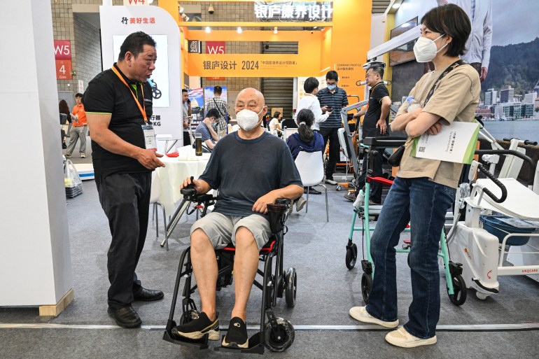 A man checks a wheelchair during the International Exhibition of Senior Care, Rehabilitation Medicine and Healthcare (CHINA AID 2024) at the Shanghai New International Expo Centre (SNIEC) in Pudong district of Shanghai on June 13, 2024. (Photo by HECTOR RETAMAL / AFP)