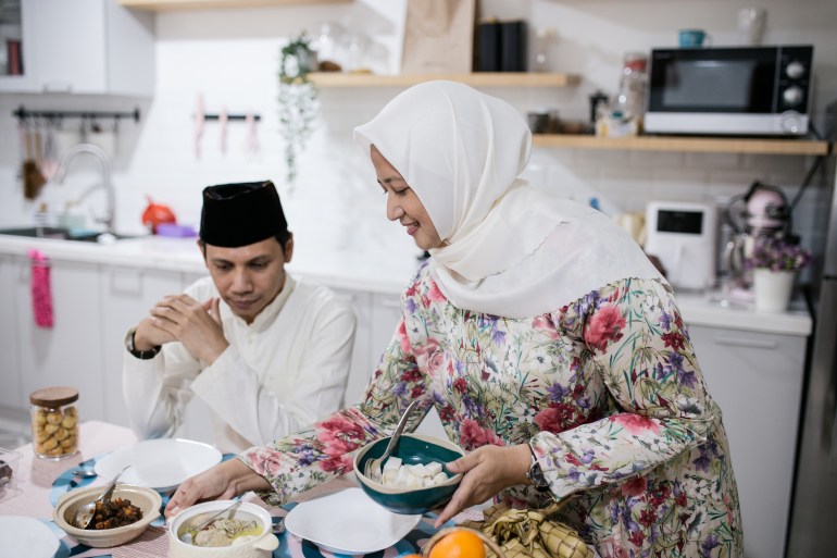 An Indonesian family are celebrating Eid-Ul-Fitr at their home. They are preparing food before having meal together with Indonesian common food for Eid-Ul-Fitr.