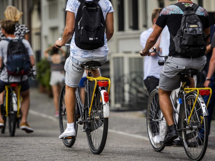 People ride on bicycles of Dutch bike rental company Yellow Bike that introduced the 'Yellow Backie' initiative, which transforms a bicycle luggage rack into an unofficial hitchhike seat in Amsterdam, The Netherlands, 13 August 2015. Fourty Amsterdam locals and volunteers have swapped their luggage racks for new, free, yellow ones. If a tourist sees a bicycle sporting one of the yellow racks on the street, they are invited to yell 'Backie!' to get a ride. The scheme enables visitors to receive a free tour of the city from a local and helps Amsterdammers connect with people from around the world.