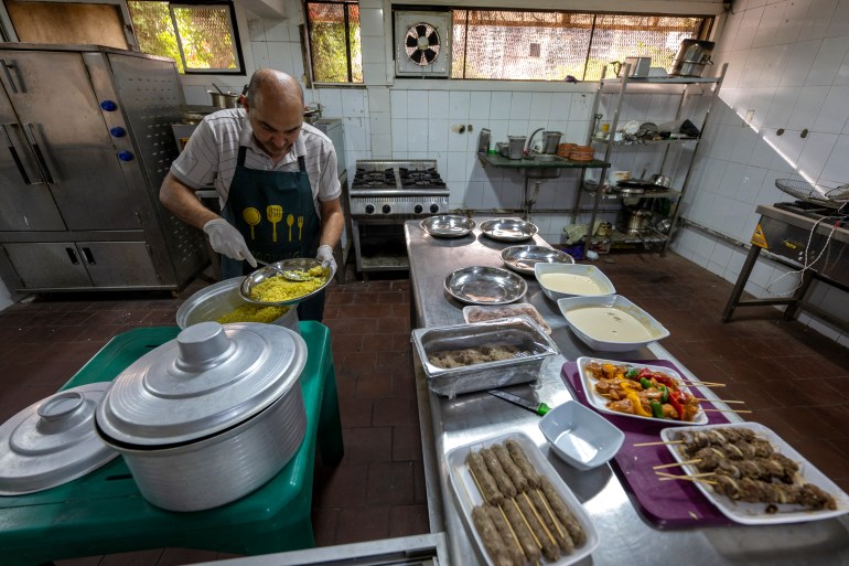 A Sudanese chief traditional food at a restaurant run by a businesswoman who relocated to the Egyptian capital Cairo after fleeing the ongoing war in Sudan, on May 21, 2024. - Across the sprawling megalopolis of Cairo, home to 20 million people, many Sudanese refugees have opened businesses, bringing a taste of home and hoping to make a name for themselves. (Photo by Khaled DESOUKI / AFP)