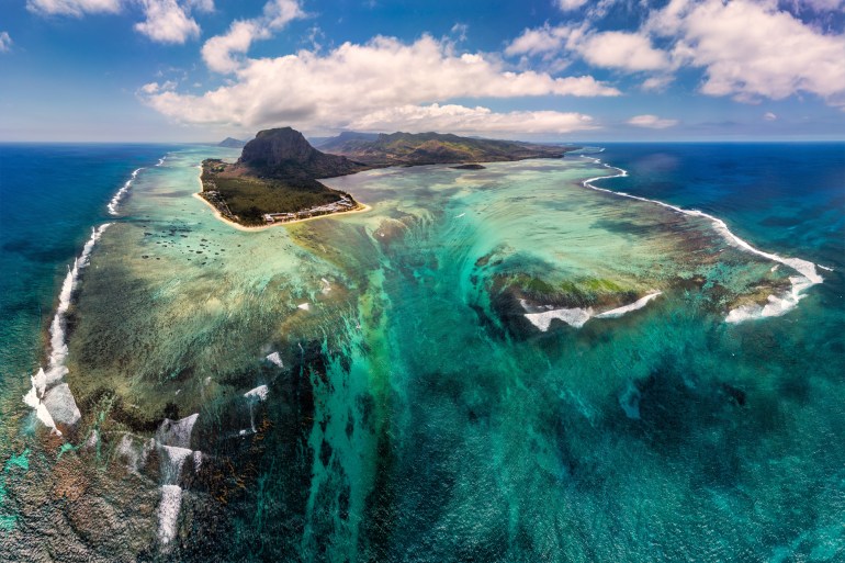 Aerial view of Mauritius island panorama and famous Le Morne Brabant mountain, beautiful blue lagoon and underwater waterfall. Le Morne Brabant peninsula and Underwater Waterfall, Mauritius شترستوك