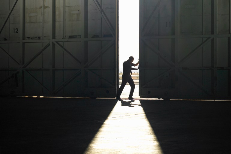 Man pushing door open - stock photo