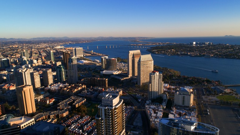 The Coronado island bridge, silver strand, downtown San Diego, harbor, and a distant Mexico island in the Pacific Ocean.