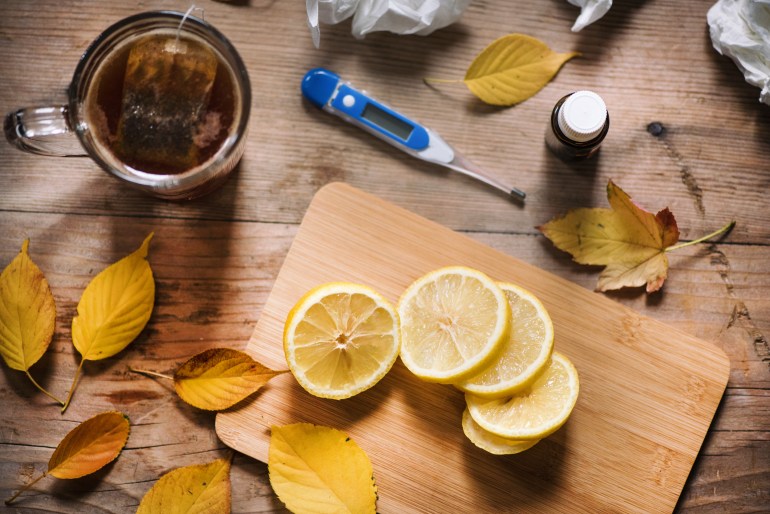 Cold and flu concept. Thermometer, medicine, tissue and a cup of tea on wooden background