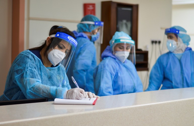 Medical staff members wearing protective gear work at a section for patients suffering from the coronavirus disease (COVID-19), inside a hospital in Amman