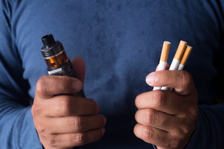 Concept of choosing the type of cigarette, a man's hand holds both types of cigarettes to choose from.