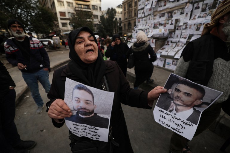 Ibtissam Al-Nadaf who said she is still mourning two sons, one killed by a sniper during the siege of Al-Assali, the other disappeared into Sednaya prison in 2018, reacts as she holds her sons photographs at Marjeh Square also known as Martyrs Square in Damascus, Syria, December 22, 2024. REUTERS/Zohra Bensemra