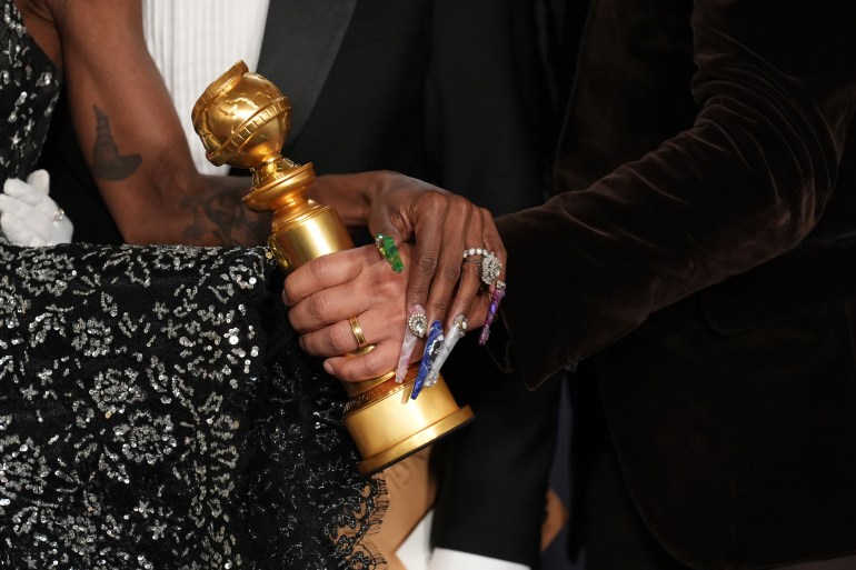 Cynthia Erivo, left, and Jon M. Chu pose with the award for cinematic and box office achievement for "Wicked" in the press room during the 82nd Golden Globes on Sunday, Jan. 5, 2025, at the Beverly Hilton in Beverly Hills, Calif. (AP Photo/Chris Pizzello)